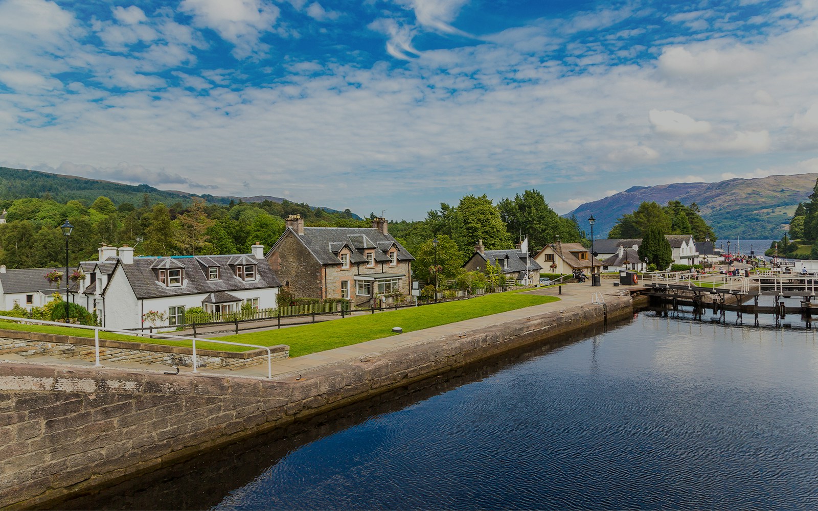 Fort Augustus, Scotland, with canal, historic buildings, and lush greenery.