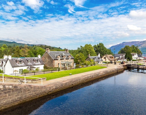 Fort Augustus, Scotland, with canal, historic buildings, and lush greenery.
