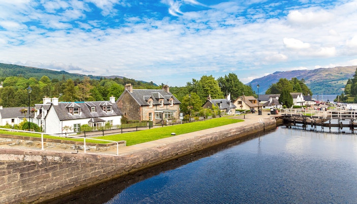 Fort Augustus, Scotland, with canal, historic buildings, and lush greenery.