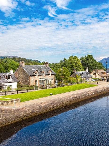 Fort Augustus, Scotland, with canal, historic buildings, and lush greenery.