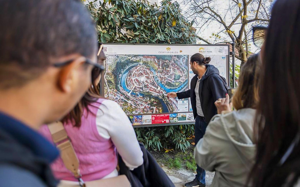 Guide explaining Cesky Krumlov map to tourists during full-day tour.