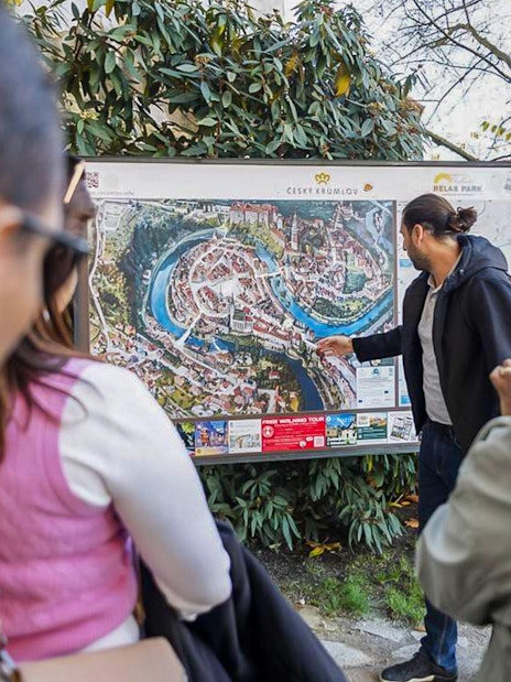 Guide explaining Cesky Krumlov map to tourists during full-day tour.