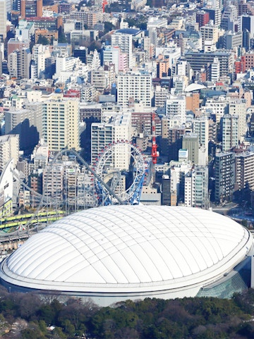 Tokyo Dome City with amusement park rides and cityscape in the background.