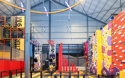 Indoor adventure hub with climbing walls and obstacle course.