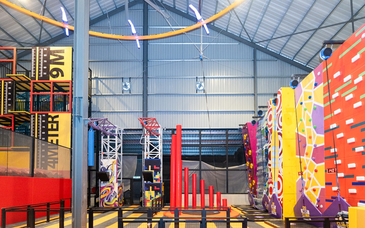 Indoor adventure hub with climbing walls and obstacle course.