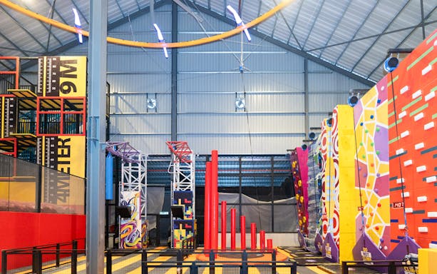 Indoor adventure hub with climbing walls and obstacle course.