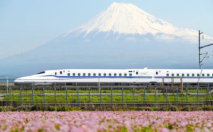 Shinkansen train passing with Mount Fuji in the background.