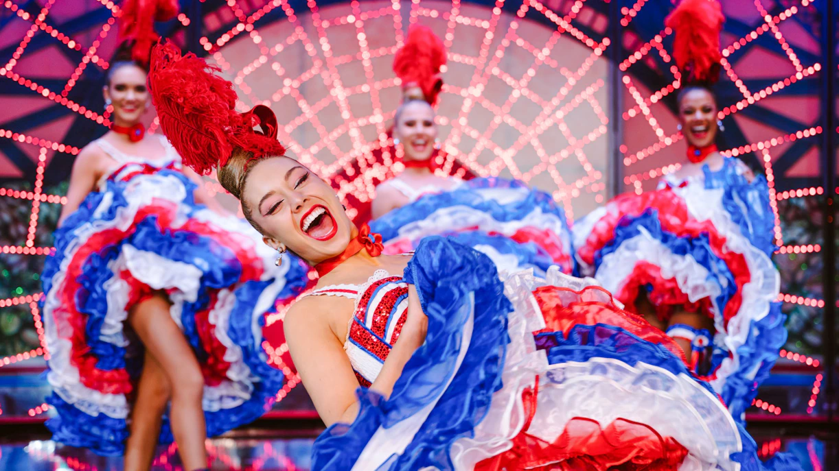 Dancers performing at the Moulin Rouge show in Paris with vibrant costumes.