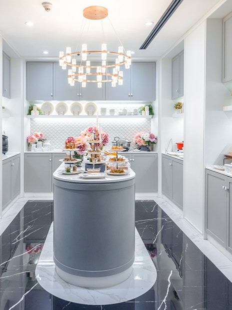 The Coral First Class Lounge buffet area at Bangkok airport, featuring snacks and beverages.