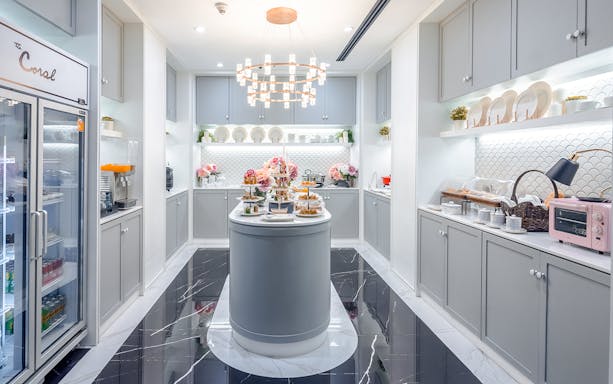 The Coral First Class Lounge buffet area at Bangkok airport, featuring snacks and beverages.