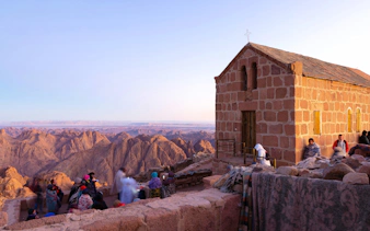 Worshippers gather at Greek Orthodox chapel on Mount Sinai at dawn, Egypt.