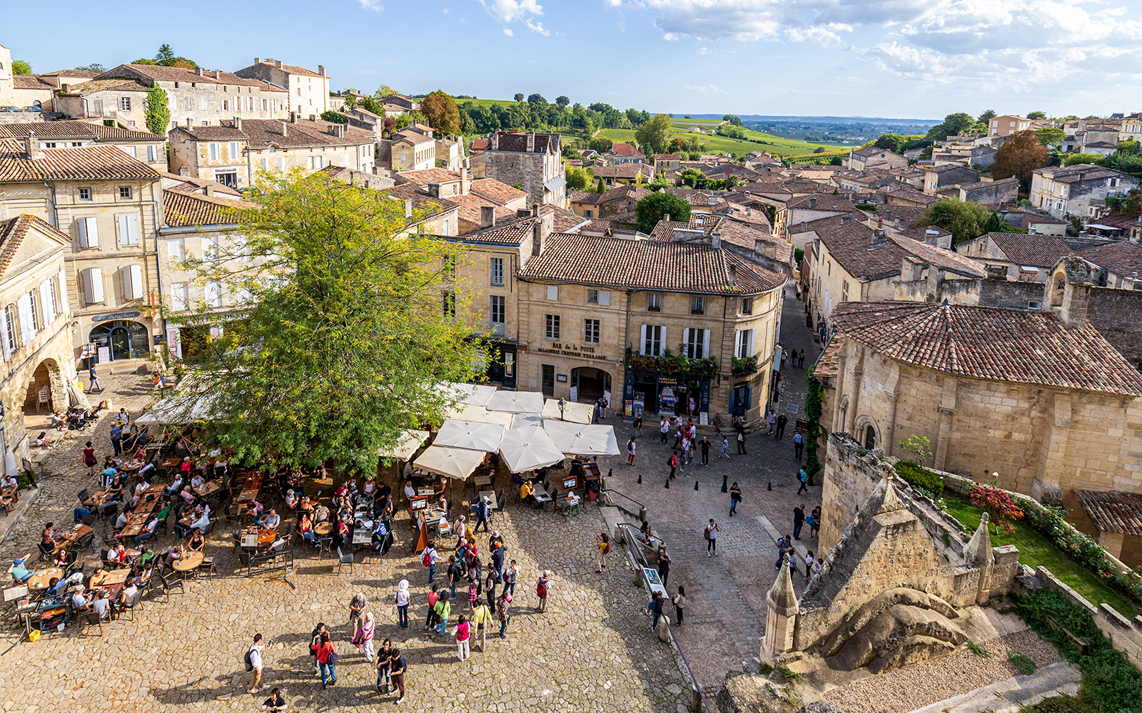 Saint-Emilion village square with outdoor café and historic architecture.