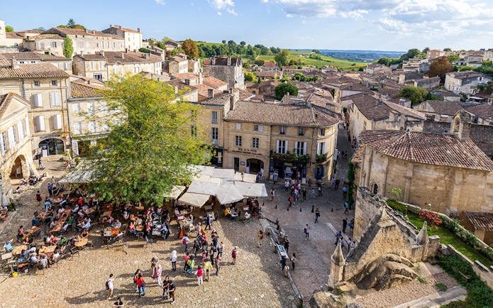 Saint-Emilion village square with outdoor café and historic architecture.