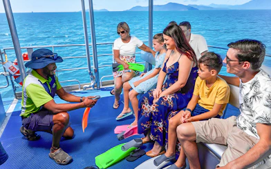 Tour guide briefing group on boat during Cairns to Green Island cruise.
