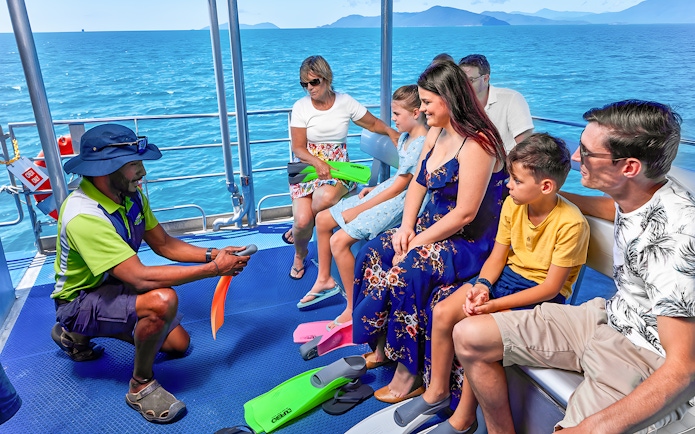 Tour guide briefing group on boat during Cairns to Green Island cruise.