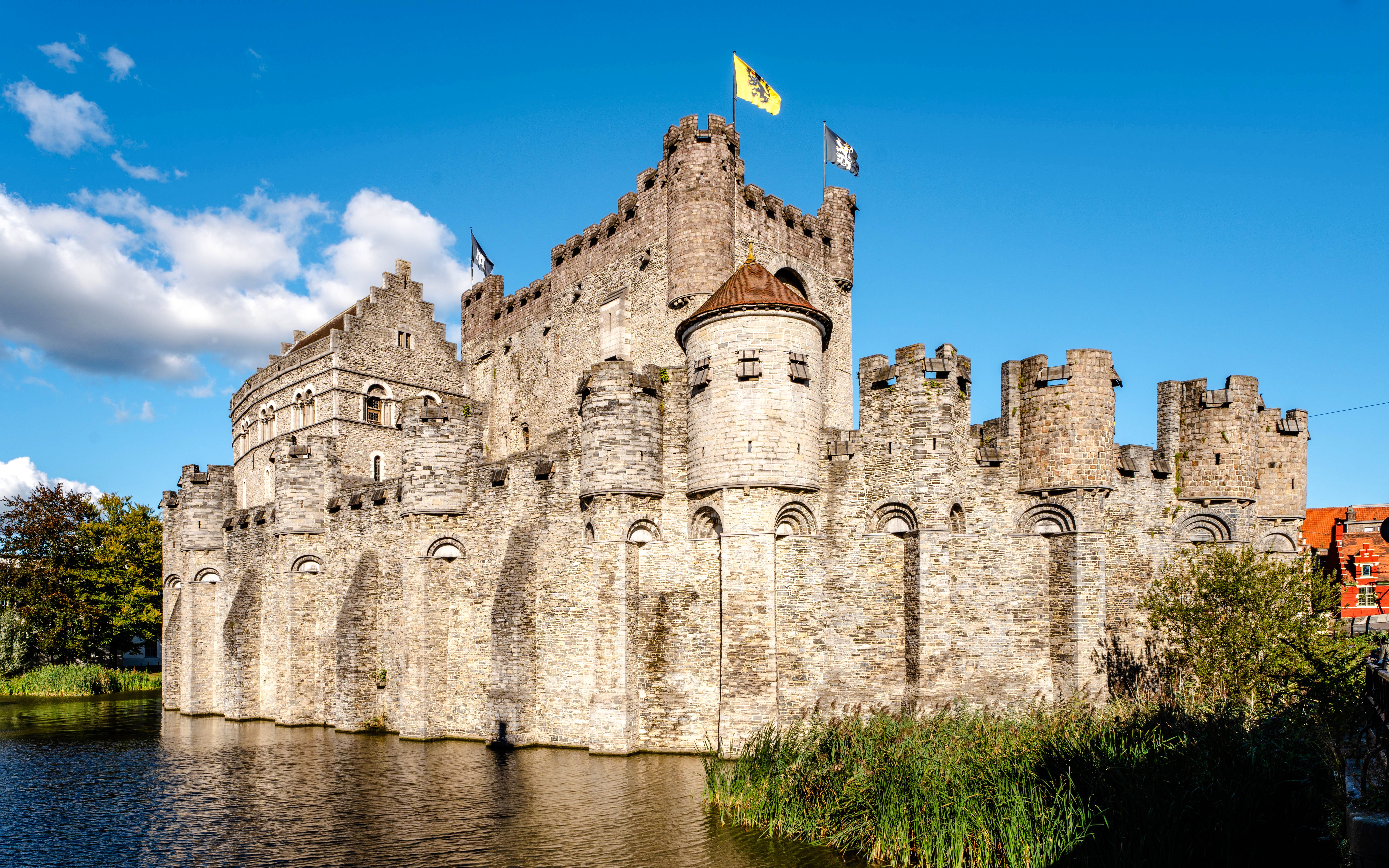 Gravensteen Castle in Ghent, Belgium, with stone walls and flags flying.