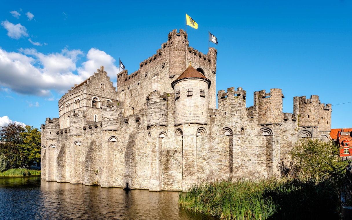 Gravensteen Castle in Ghent, Belgium, with stone walls and flags flying.