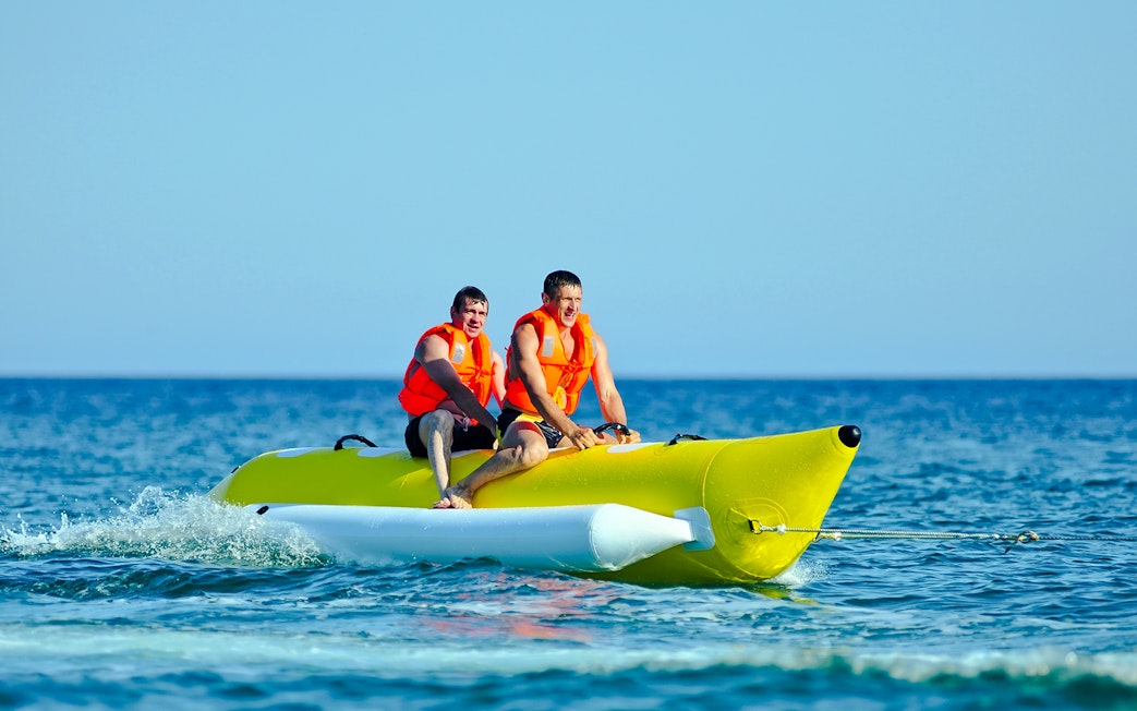 Two people riding a banana boat on a Langkawi day cruise.