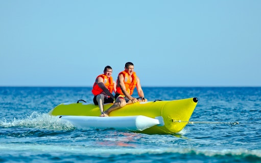 Two people riding a banana boat on a Langkawi day cruise.
