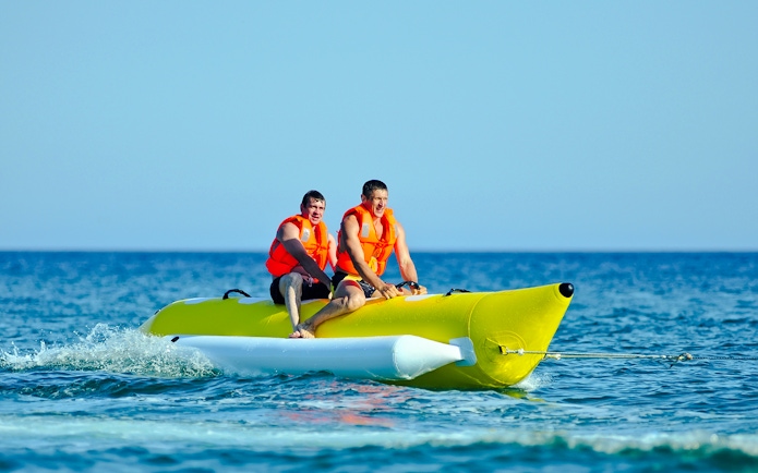 Two people riding a banana boat on a Langkawi day cruise.