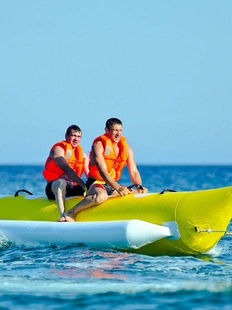 Two people riding a banana boat on a Langkawi day cruise.
