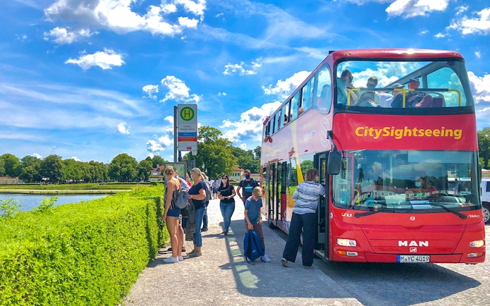 Tourists boarding Citysightseeing bus at Schloss Nymphenburg stop in Munich.