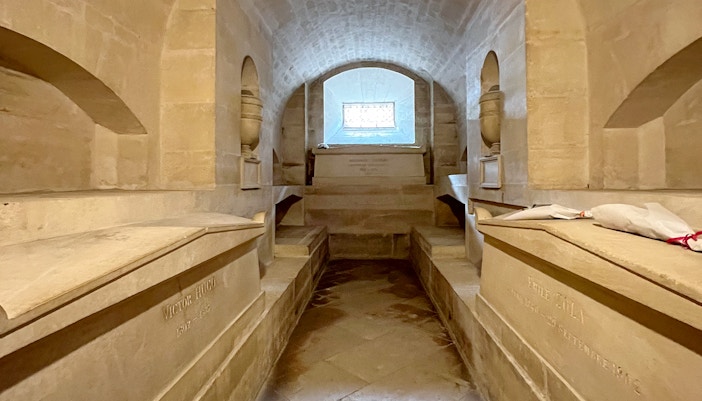 Tombs in the crypt of Paris Pantheon with historical inscriptions.