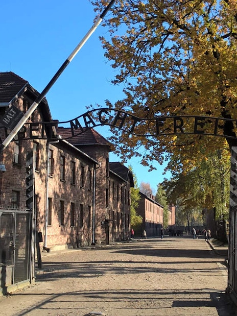 Entrance gate to Auschwitz concentration camp with "Arbeit Macht Frei" sign, part of Krakow day tour.