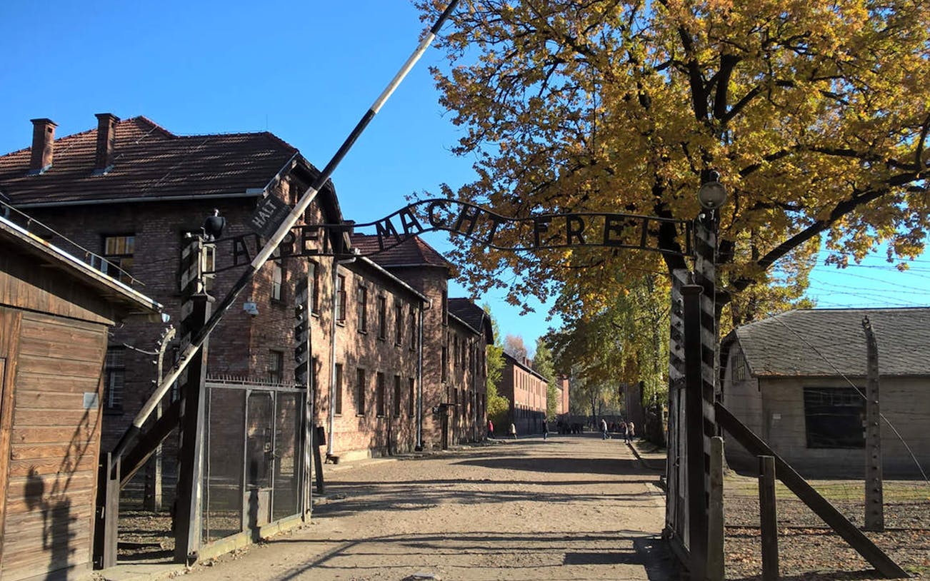 Entrance gate to Auschwitz concentration camp with "Arbeit Macht Frei" sign, part of Krakow day tour.