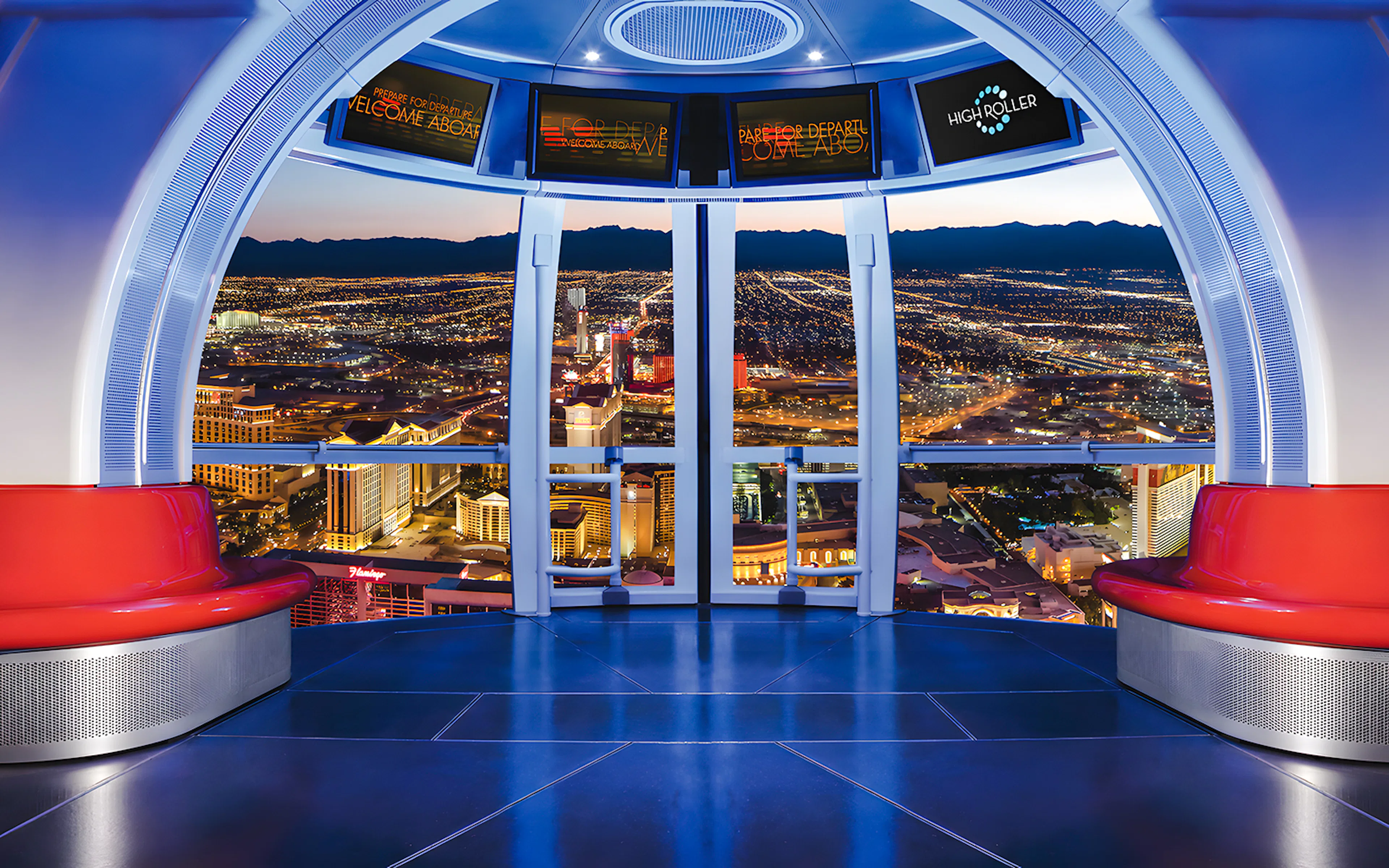View from High Roller Wheel cabin overlooking Las Vegas skyline at night.