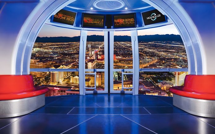 View from High Roller Wheel cabin overlooking Las Vegas skyline at night.