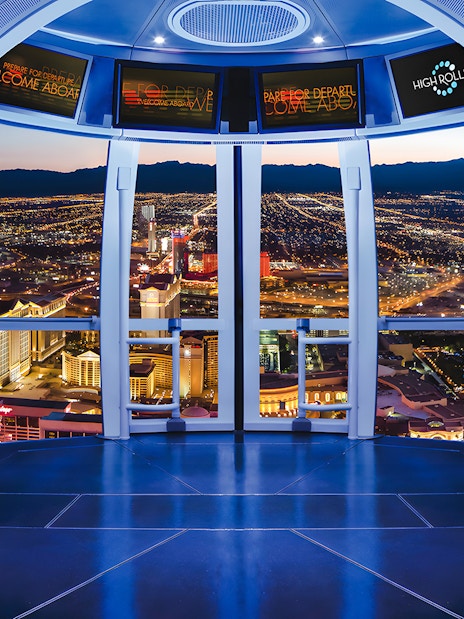 View from High Roller Wheel cabin overlooking Las Vegas skyline at night.