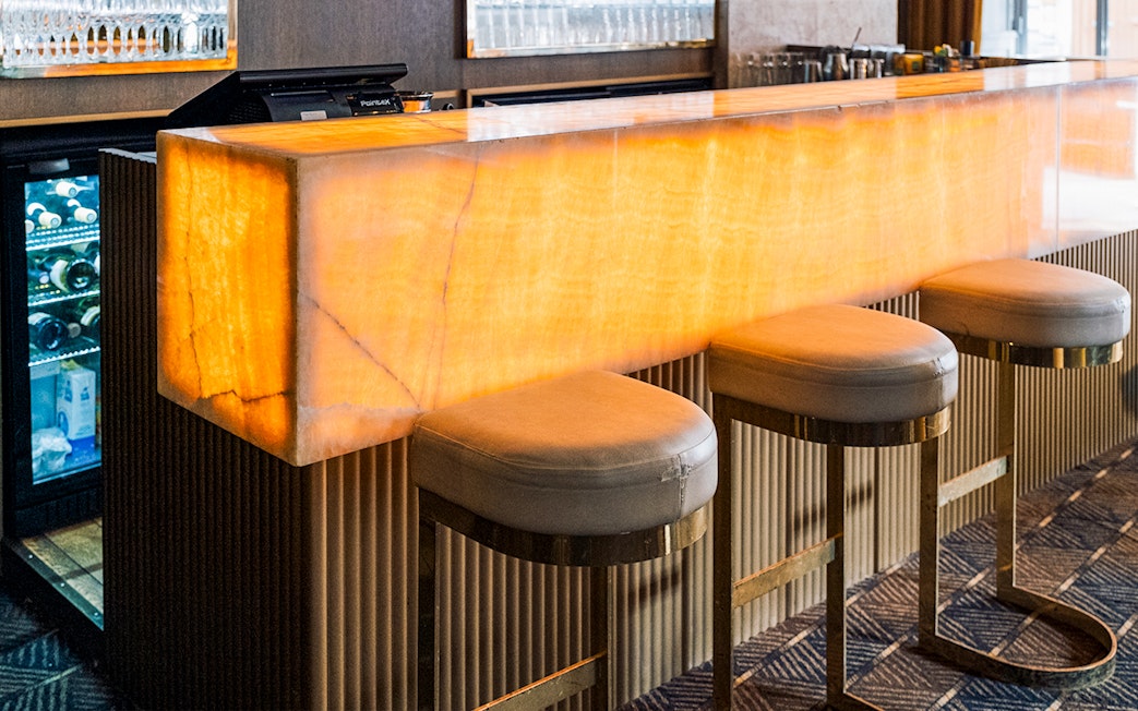 Bar area at Crazy Horse Paris Show and Dinner with illuminated counter and stools.