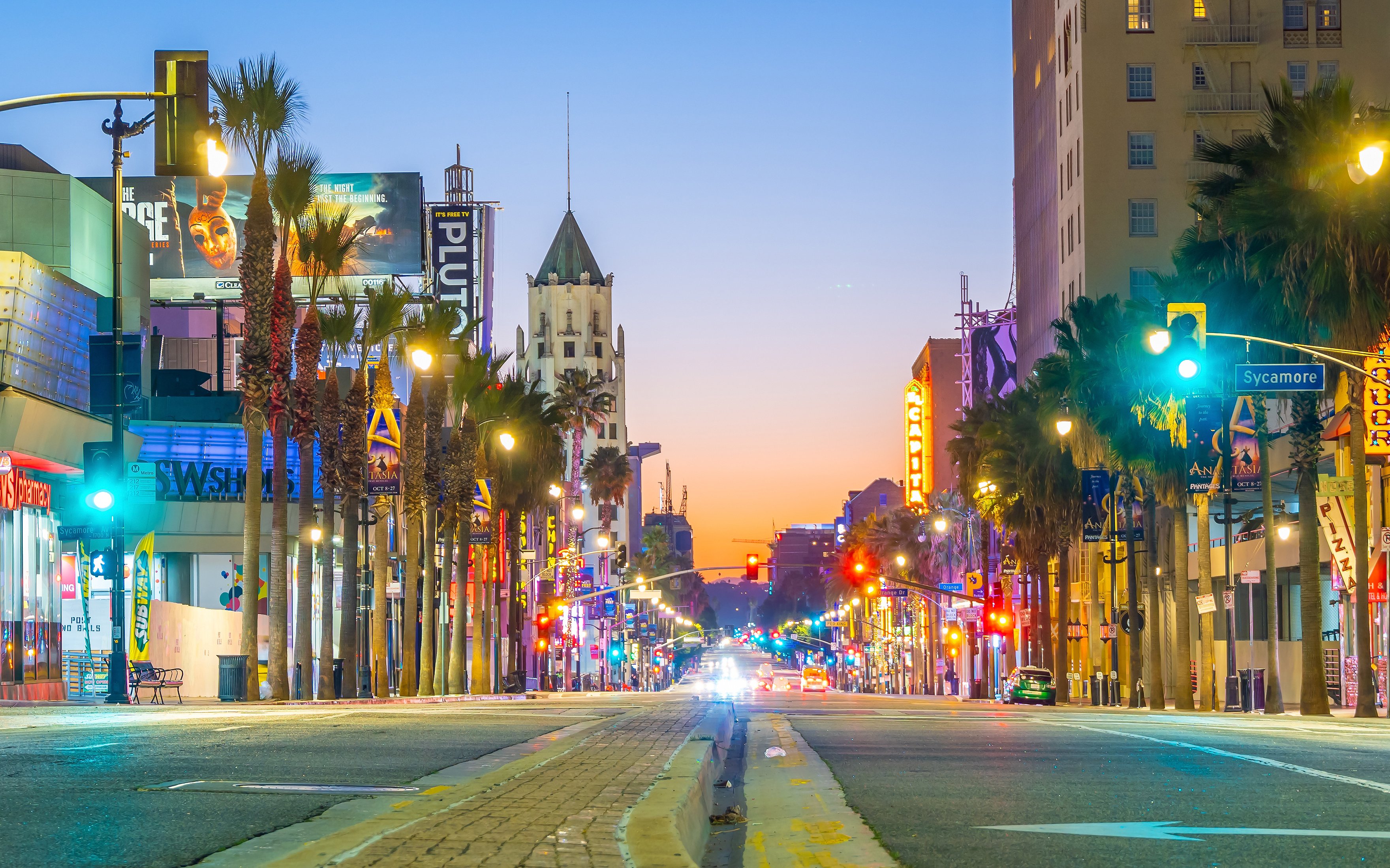 Hollywood Boulevard at dusk with neon lights and palm trees, Los Angeles.