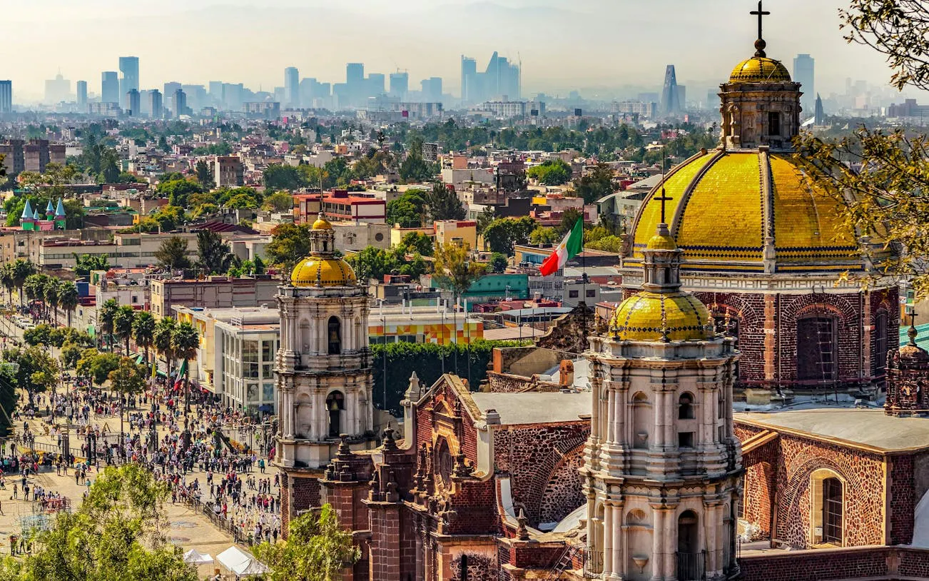 Basilica of Our Lady of Guadalupe with Mexico City skyline in the background.