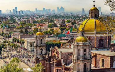Basilica of Our Lady of Guadalupe with Mexico City skyline in the background.