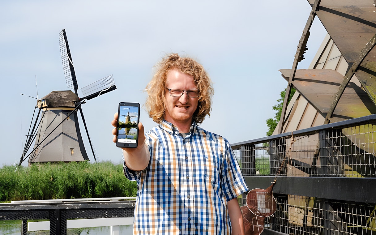 Visitor using audio guide at Kinderdijk windmills in the Netherlands.