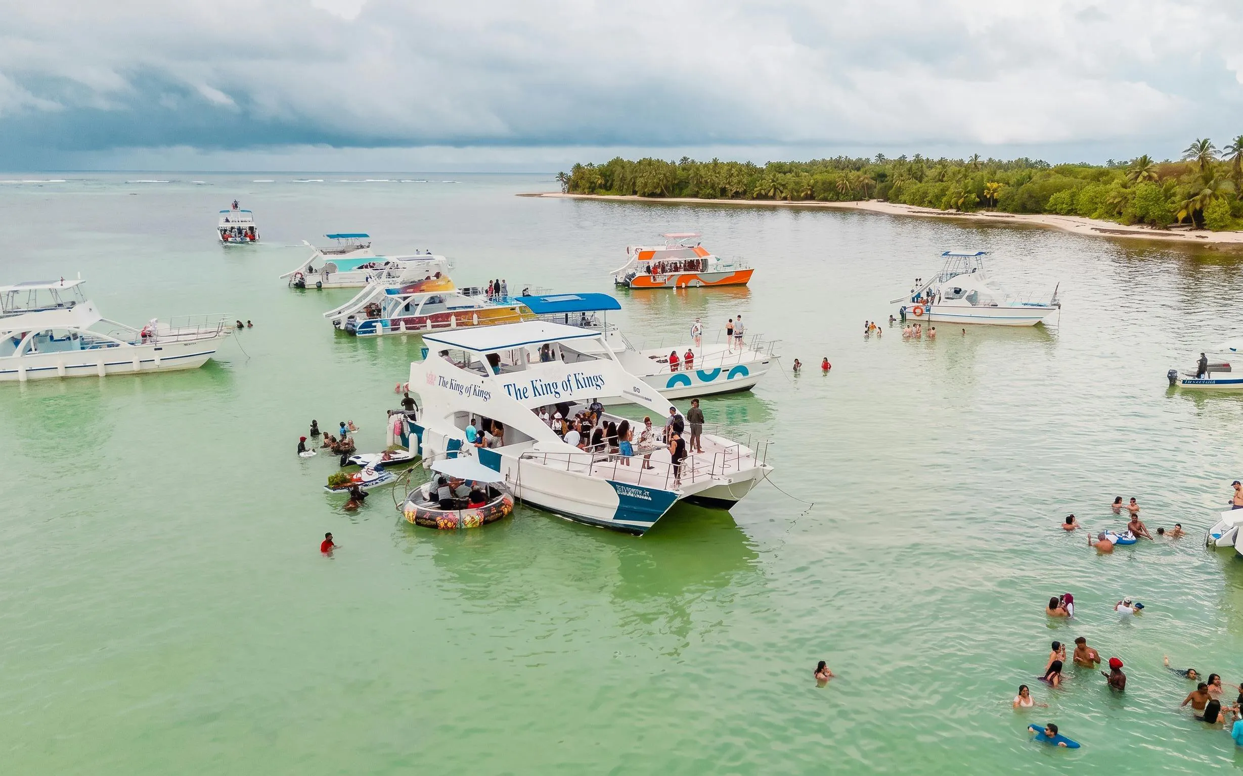 Boat party with snorkeling in the Caribbean Sea near Punta Cana, featuring multiple boats and swimmers.