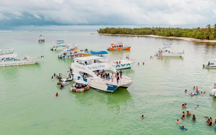 Boat party with snorkeling in the Caribbean Sea near Punta Cana, featuring multiple boats and swimmers.