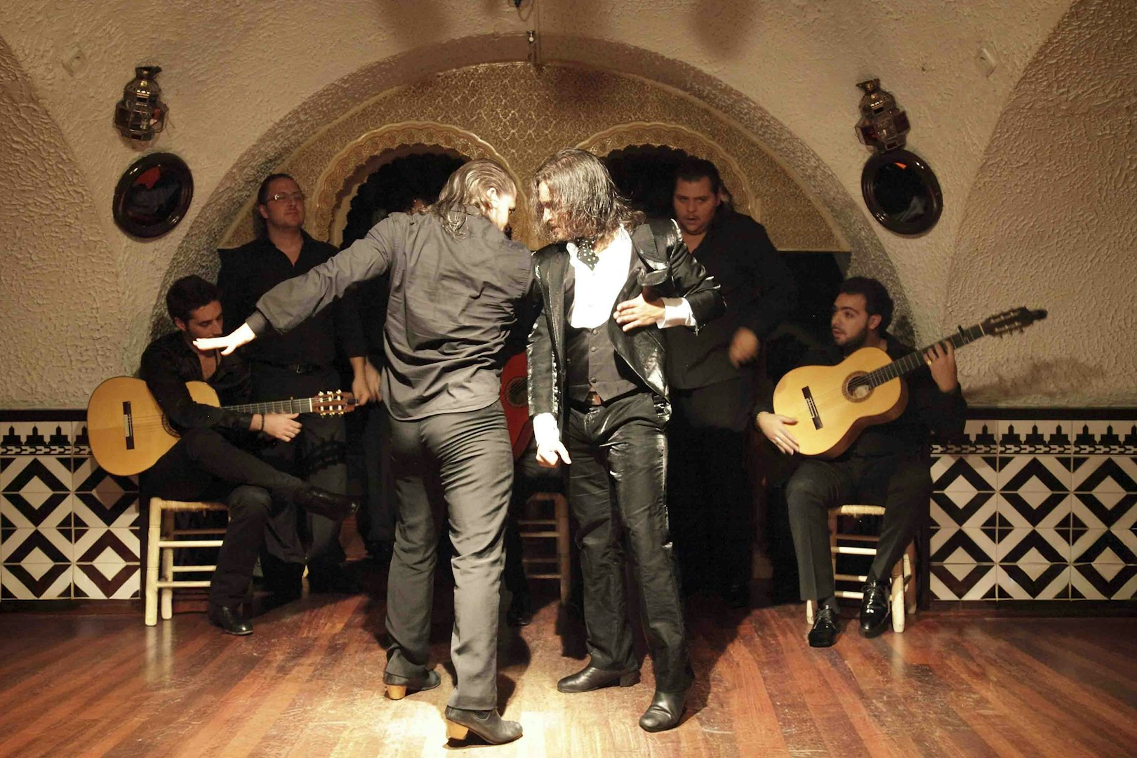 Flamenco dancers performing at Tablao Cordobes with guitarists in the background.