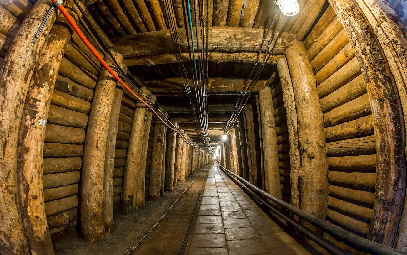 Underground tunnel in Bochnia Salt Mine, Krakow, with wooden supports and lighting.