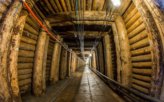Underground tunnel in Bochnia Salt Mine, Krakow, with wooden supports and lighting.