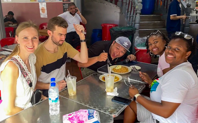 Group enjoying local cuisine at a street food stall during Bike and Bites Food Tour.