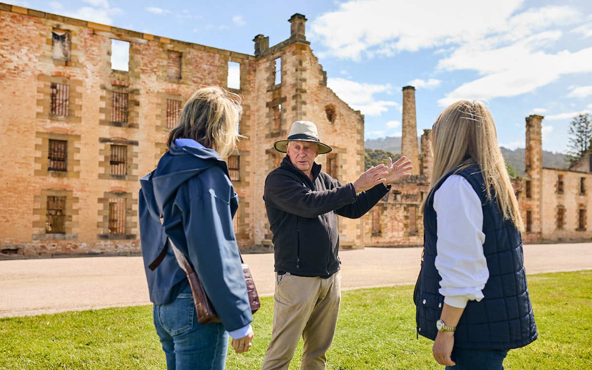Tour guide explaining history to visitors at Port Arthur Historic Site, Tasmania.