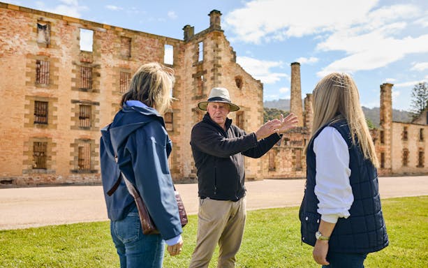 Tour guide explaining history to visitors at Port Arthur Historic Site, Tasmania.