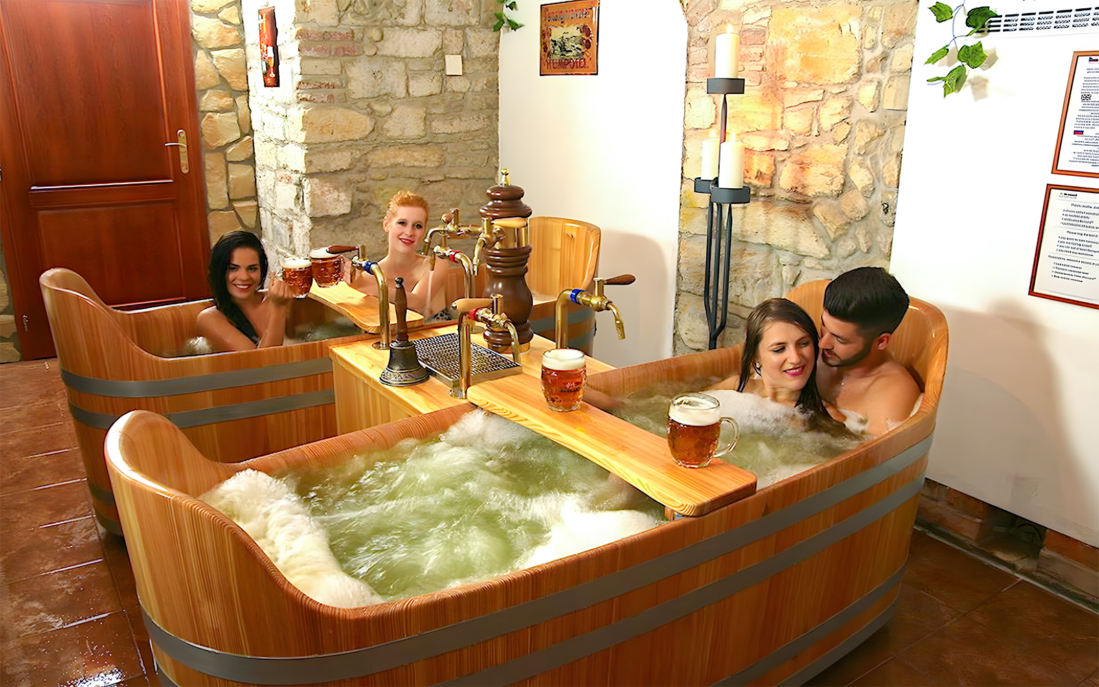 Group of friends at Bernard Beer Spa beer bath experience with wooden tubs in Prague, Czech Republic.