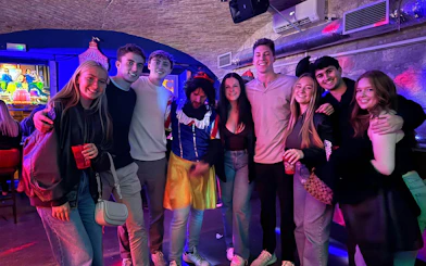 Group enjoying a pub and bar tour with themed costumes and drinks.