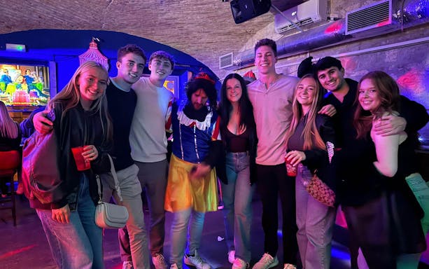 Group enjoying a pub and bar tour with themed costumes and drinks.