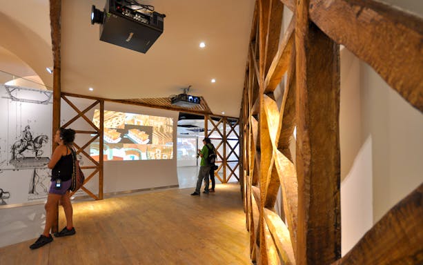 Tourists viewing historical exhibits inside Lisboa Story Centre.