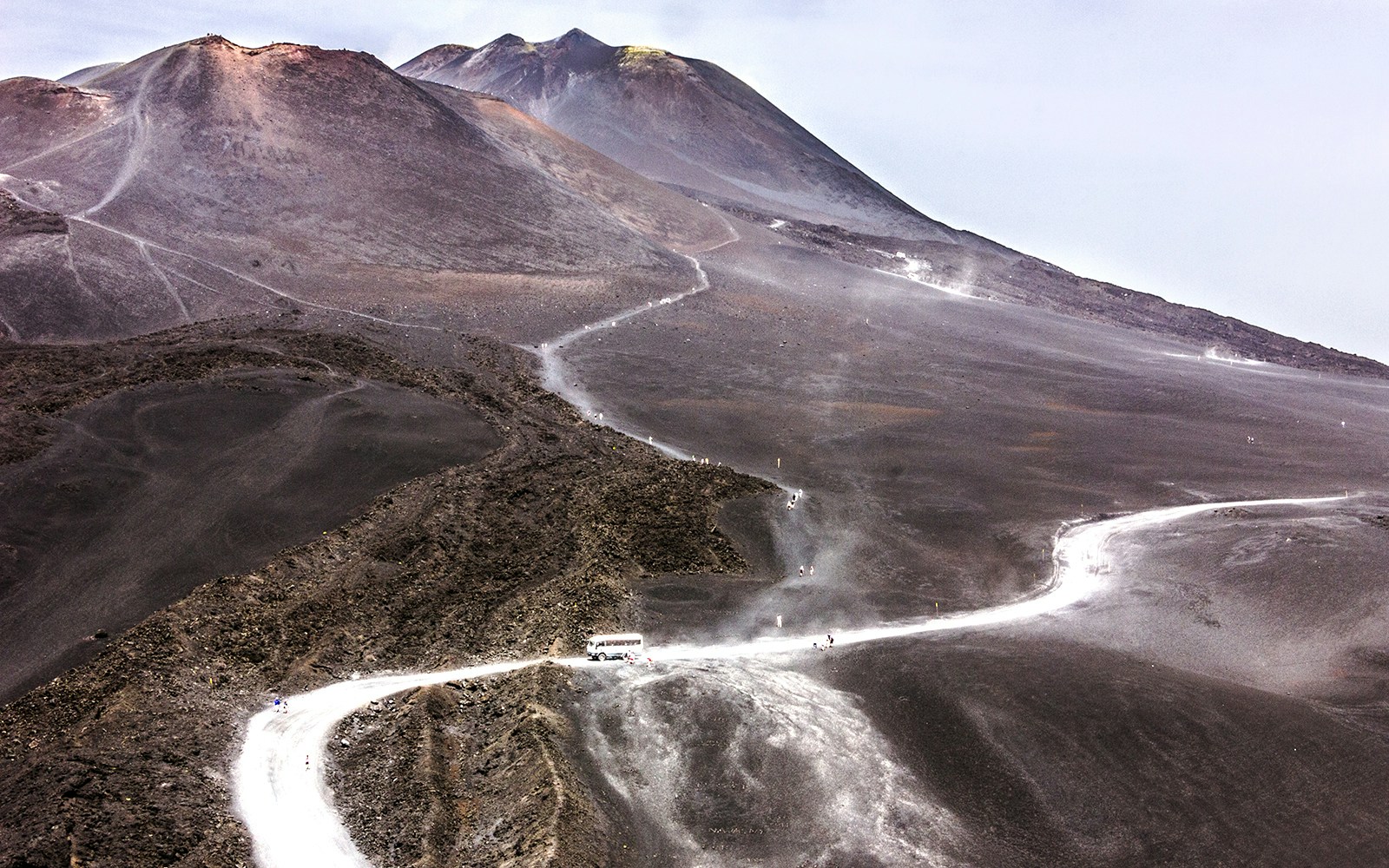 Mount Etna Montagnola volcanic landscape with rugged terrain and distant smoke plume in Sicily, Italy.